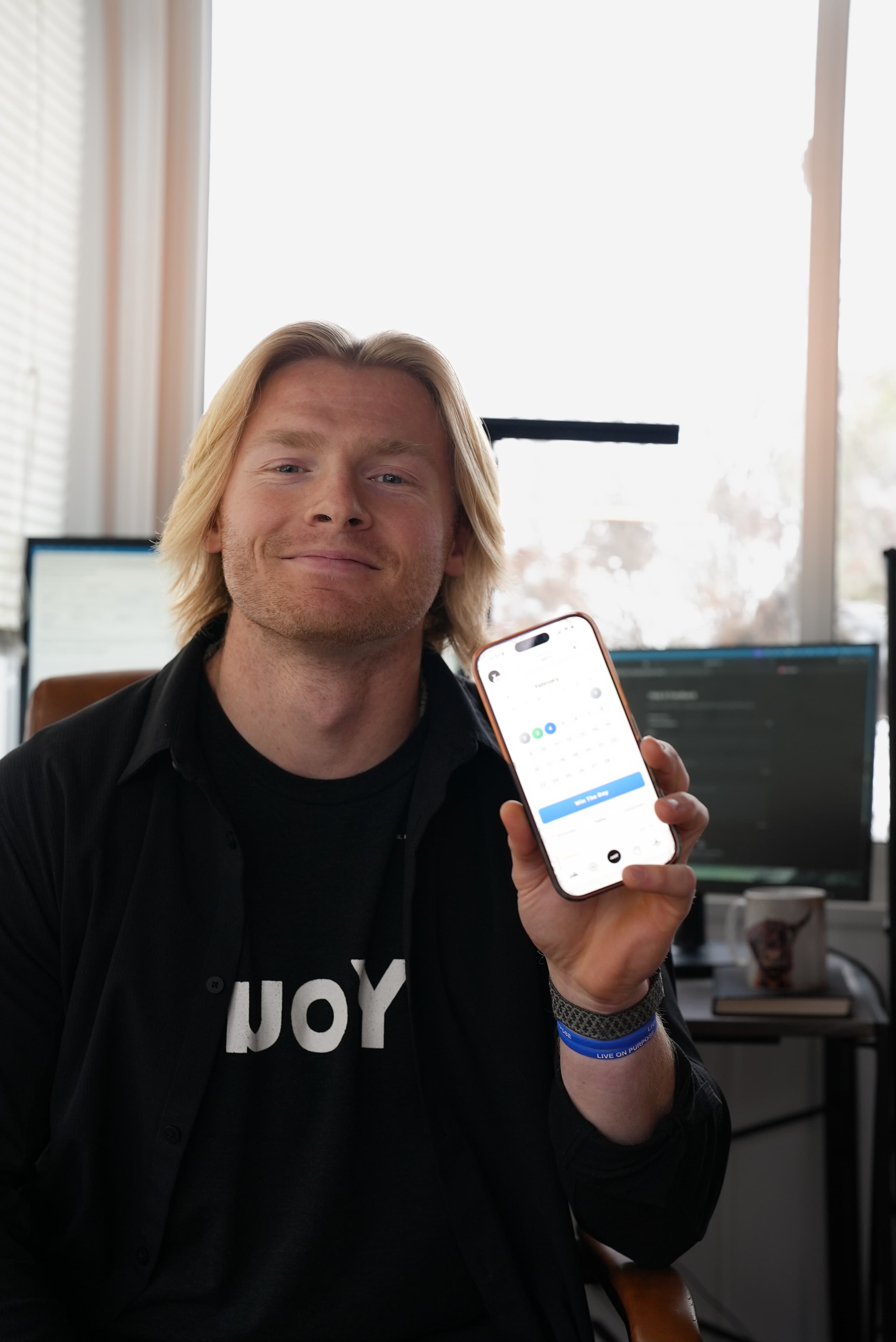 Harrison holding the YOU.PRJCT+ app