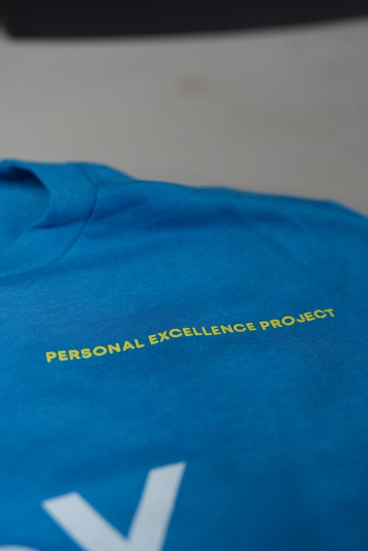The yellow chest line printed on blue heather, up close