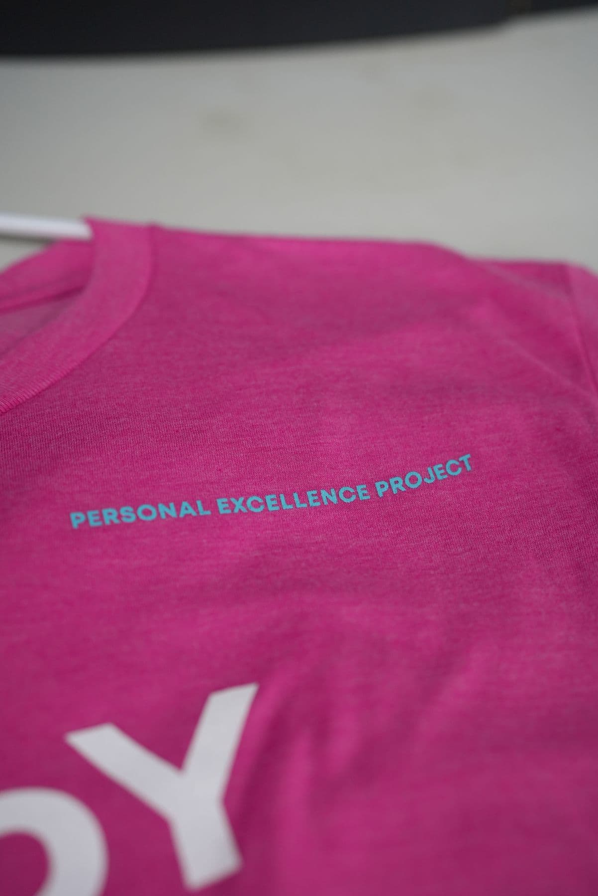 The cyan chest line printed on pink heather, up close