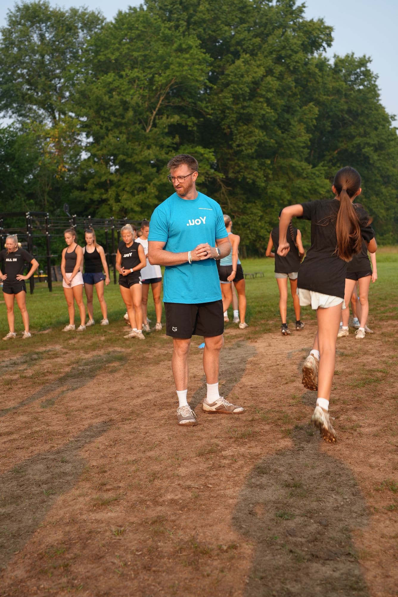 The blue tee worn on the field while a session runs behind