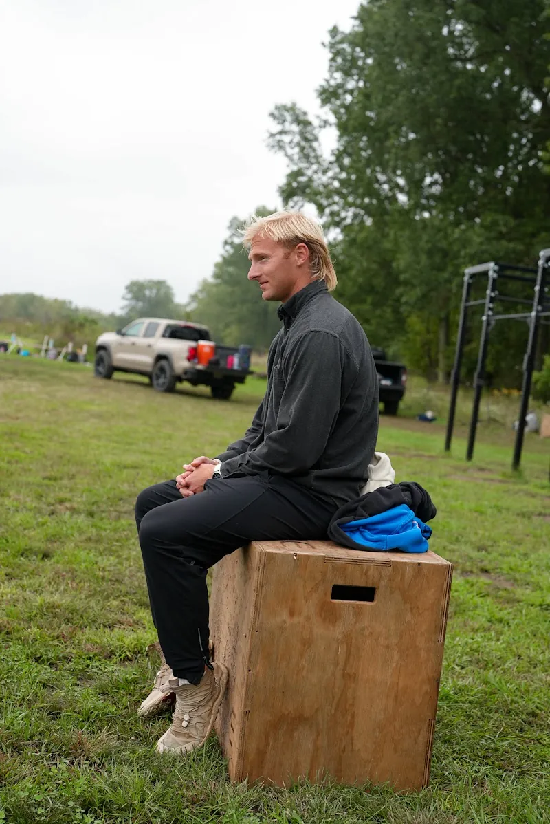 Henry Schertzinger sitting on a plyo box at the edge of the field