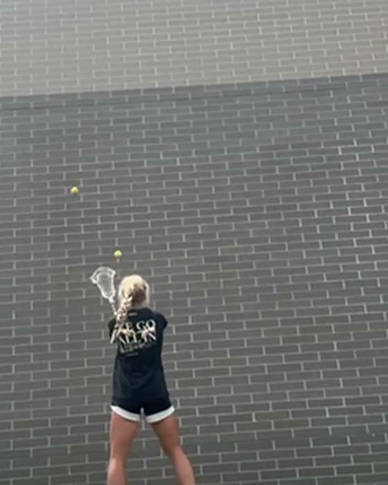 Ryley doing wall ball against a brick wall